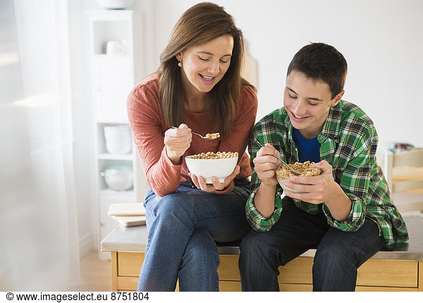 Caucasian mother and son eating cereal together