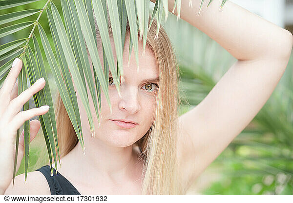 Caucasian woman near green palm branch  lifestyle portrait