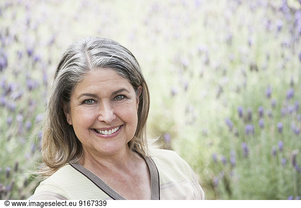 Caucasian woman smiling in lavender field