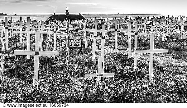 Cemetery with wooden cross grave markers and a view of the coastline; Nuuk  Sermersooq  Greenland