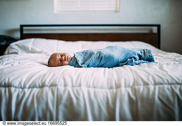 center portrait of newborn sleeping on bed