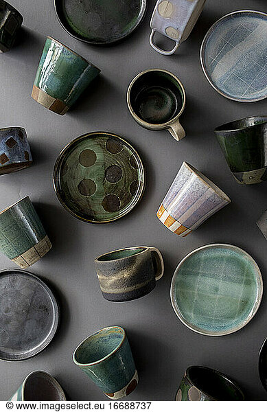 Ceramic cups  plates  and mugs on gray surface