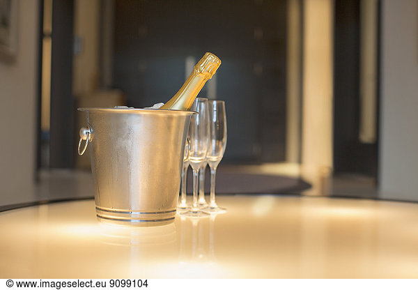 Champagne in silver bucket next to champagne flute