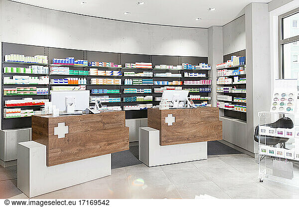 Checkout counters against shelves with medicines at pharmacy
