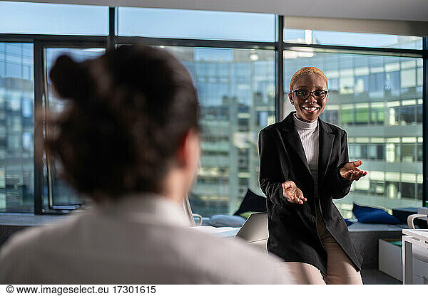 Cheerful black businesswoman talking during conference