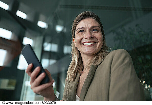 Cheerful blond businesswoman with smart phone