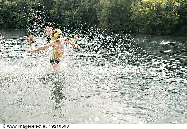 Cheerful boy enjoying with family in river