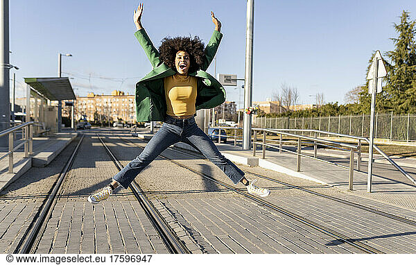 Cheerful businesswoman jumping on tramway