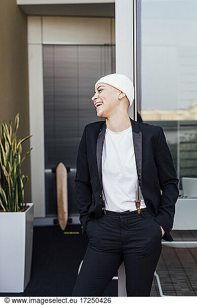 Cheerful businesswoman leaning on office door
