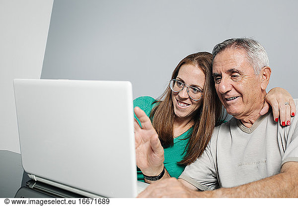 Cheerful couple having video conversation via laptop