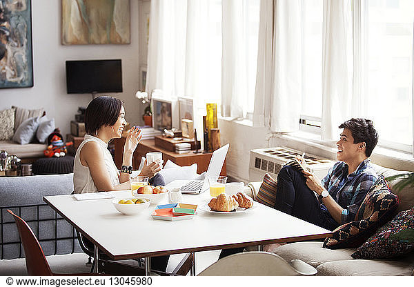 Cheerful couple spending leisure time in living room