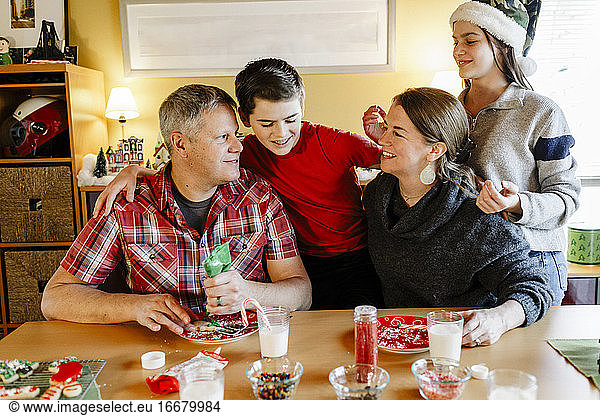 Cheerful family of four after decorating xmas cookies at home