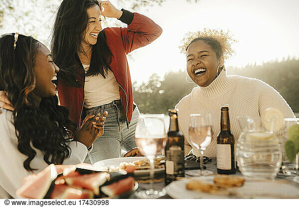 Cheerful female friends laughing while enjoying party