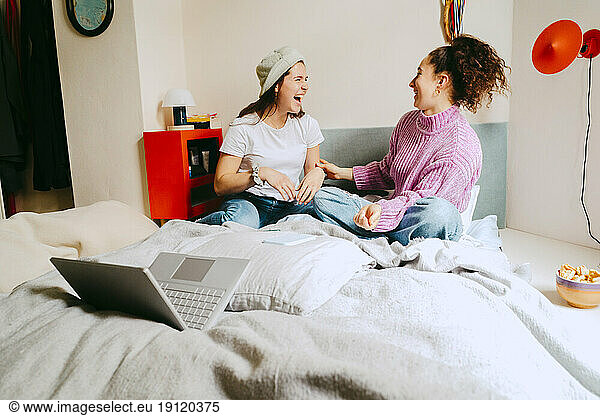 Cheerful female friends spending leisure time together at home