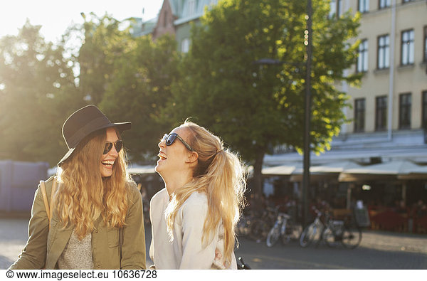 Cheerful female friends standing on city street