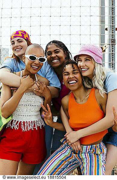 Cheerful friends embracing each other in front of net