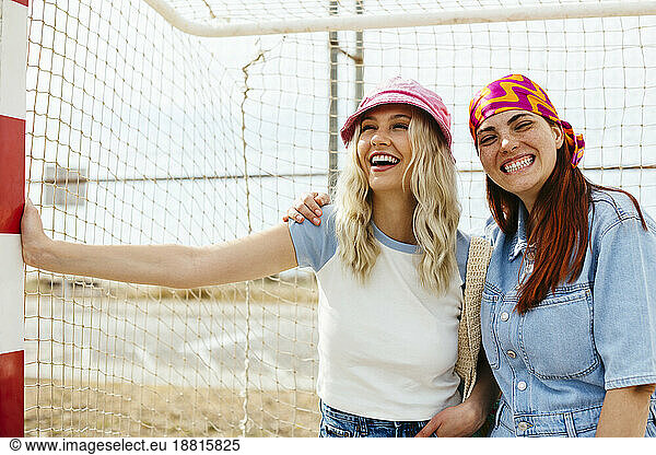 Cheerful friends enjoying near goalpost