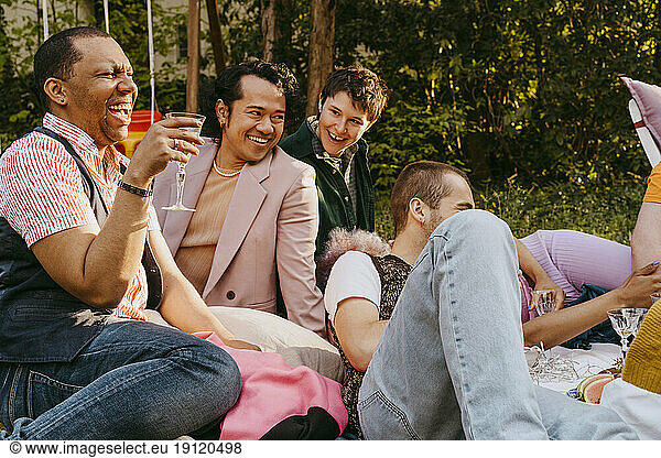 Cheerful friends from LGBTQ community having fun during party in back yard