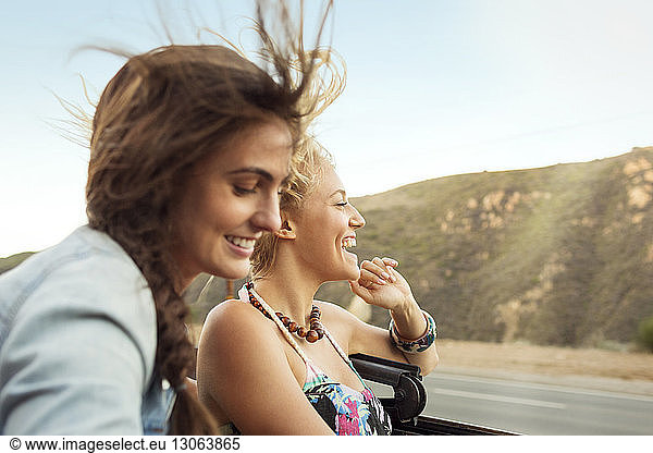 Cheerful friends travelling in convertible car