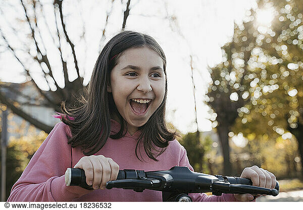Cheerful girl riding electric scooter