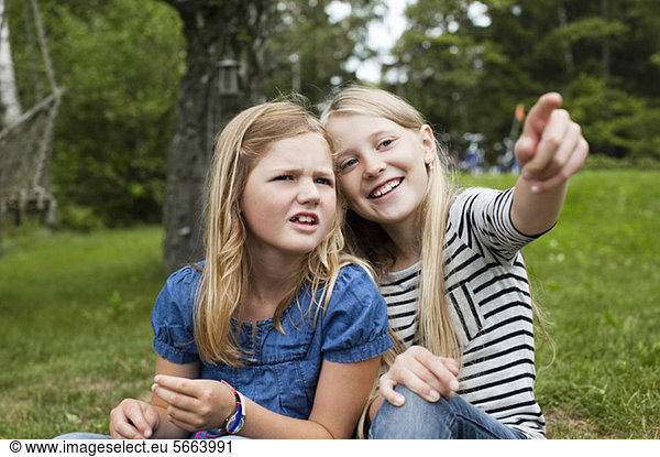 Cheerful girl showing something to sister