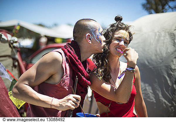 Cheerful man and woman with face paints enjoying during traditional event