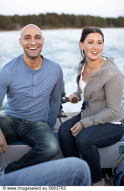 Cheerful man with woman riding motorboat