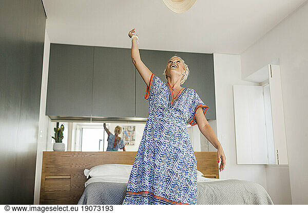 Cheerful mature woman enjoying vacations in apartment