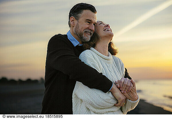 Cheerful mature woman enjoying with man at beach