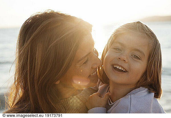 Cheerful mother and daughter enjoying at beach