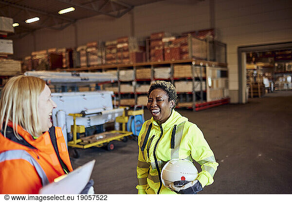Cheerful multiracial female blue-collar workers in distribution warehouse