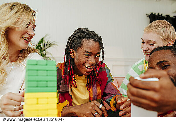 Cheerful multiracial friends spending leisure time together at home