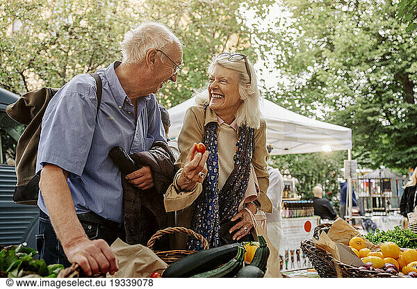 Cheerful senior woman and man enjoying at market