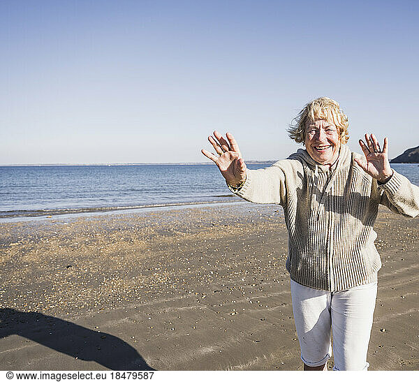 Cheerful senior woman at beach on sunny day