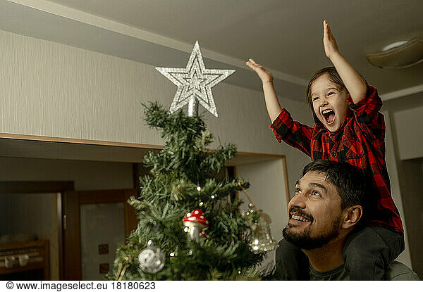Cheerful son and father enjoying together on Christmas at home