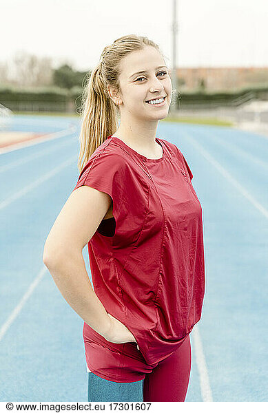 Cheerful sportswoman during track and field training