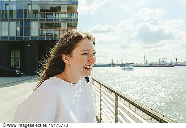 Cheerful teenage girl enjoying weekend by Elbe river at harbor