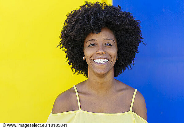Cheerful young woman in front of two tone color wall