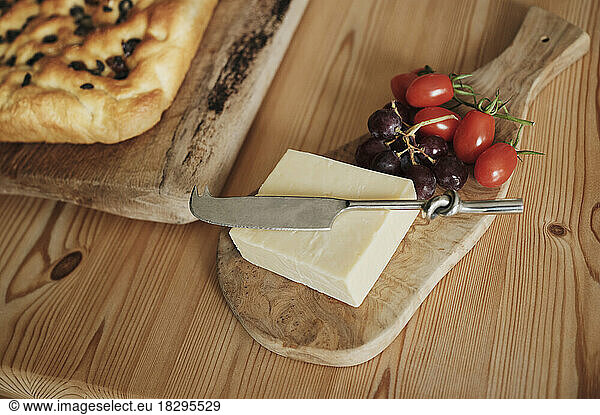Cheese with tomatoes and grapes with foccaccia on kitchen table