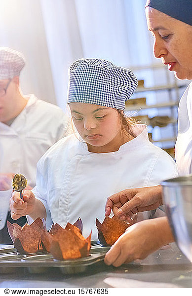 Chef and student with Down Syndrome baking muffins