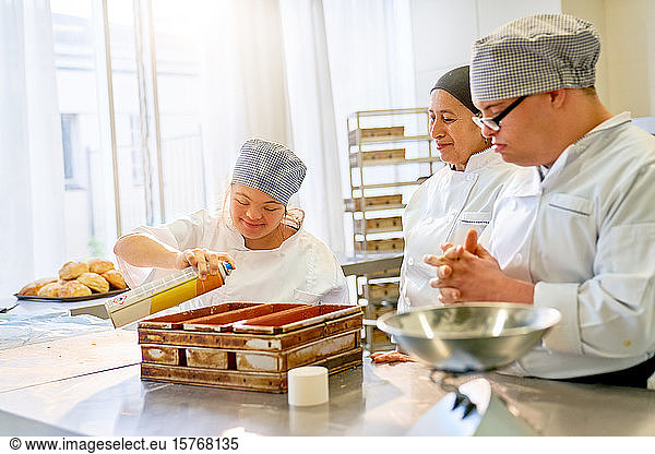 Chef and students with Down Syndrome baking bread in kitchen