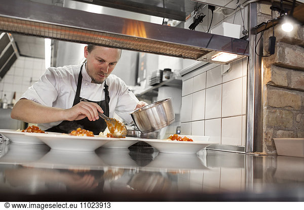Chef serving food in plate at kitchen counter restaurant