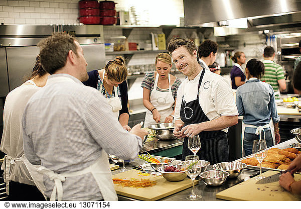 Chef teaching students at commercial kitchen