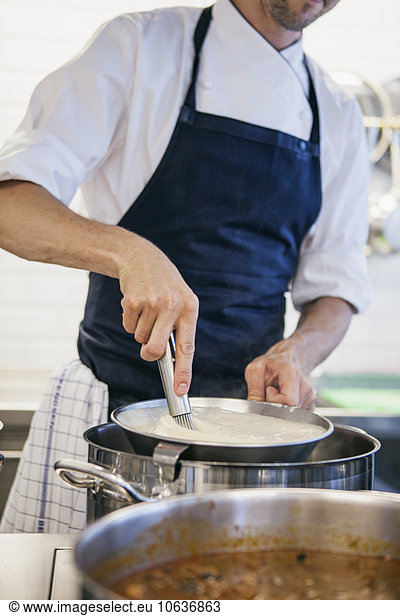 Chef whipping milk at restaurant kitchen