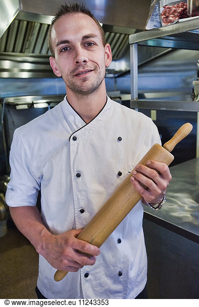 Chef with rolling pin in kitchen