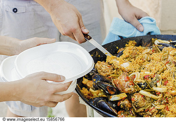 Chefkoch serviert typisch spanische Paella mit Meeresfrüchten