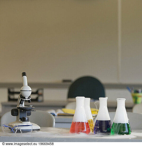 Chemistry equipment on laboratory bench  microscope and beakers.