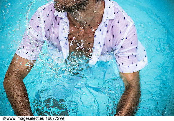 Chest of a man in the pool with white shirt
