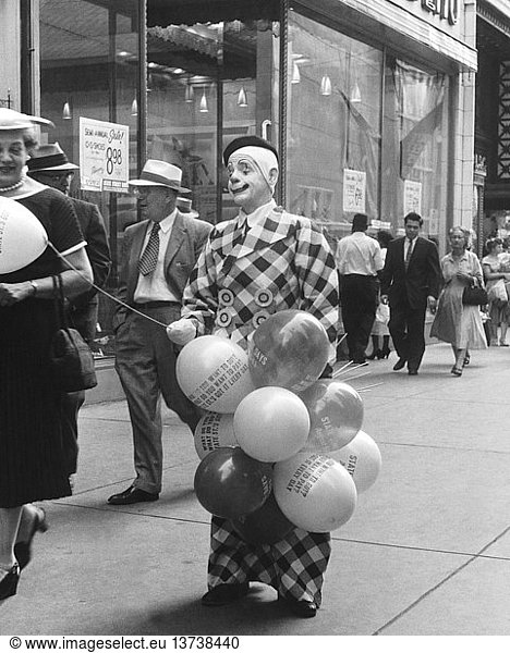 Chicago  Illinois: August 11  1956 A man in a clown outfit passing out promotional balloons advertising ´State Street Days´.