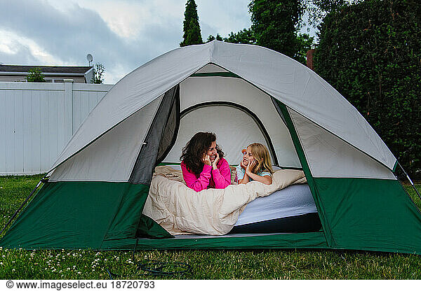 child and adult in tent in backyard